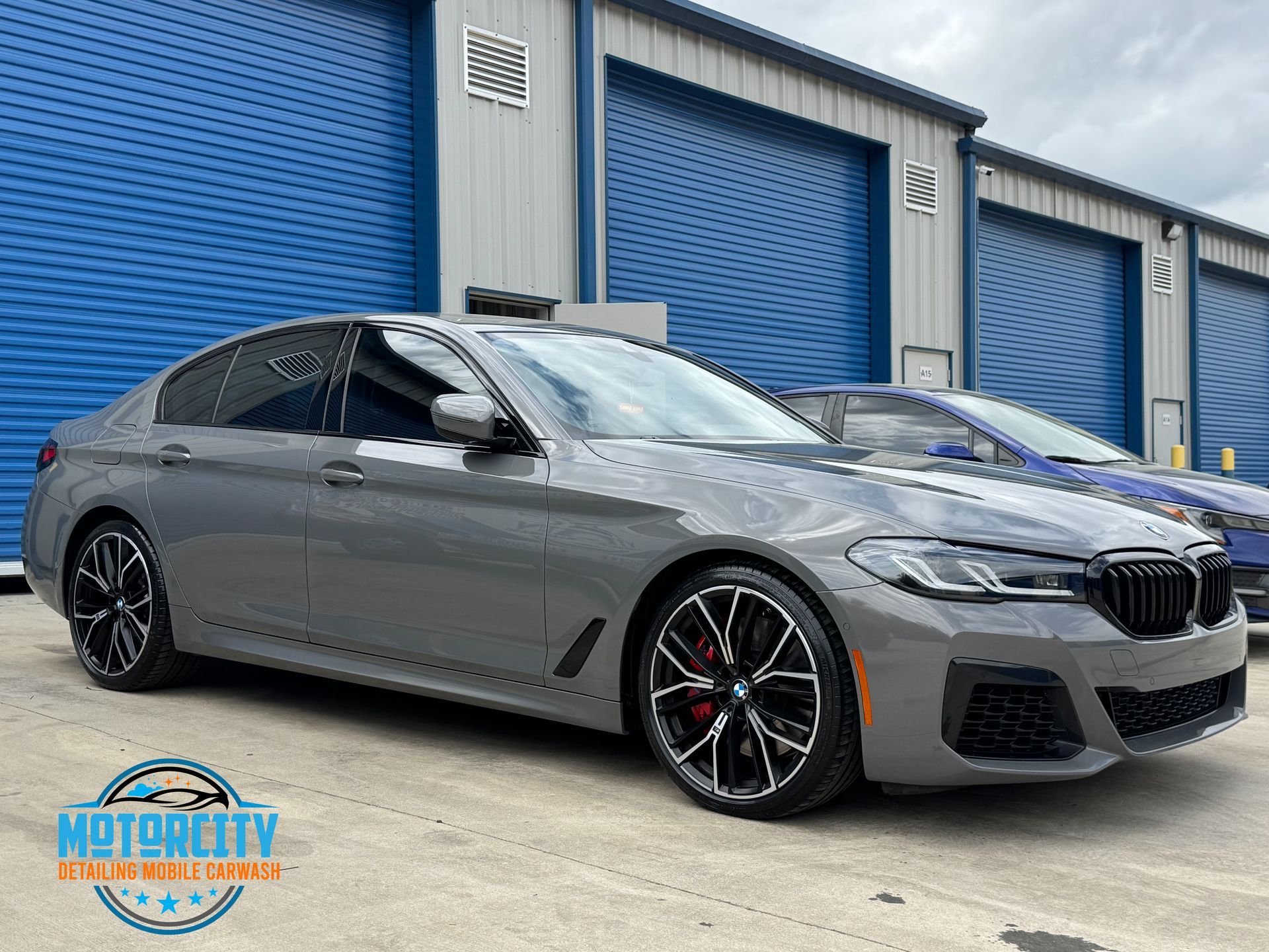 A blue bmw 4 series is parked in a parking lot.