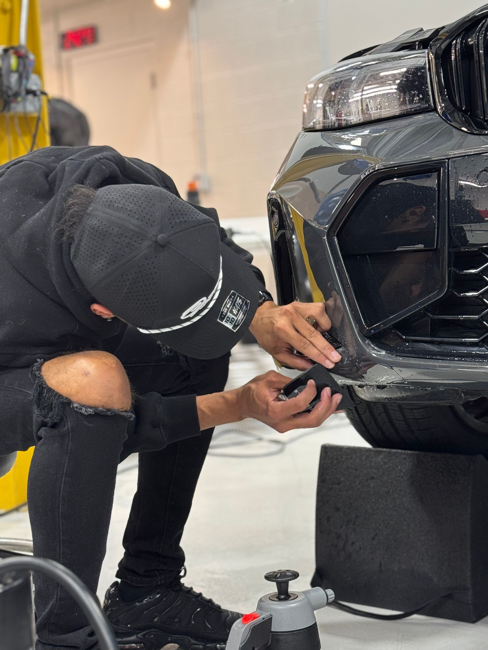 A group of people are working on a car in a garage.