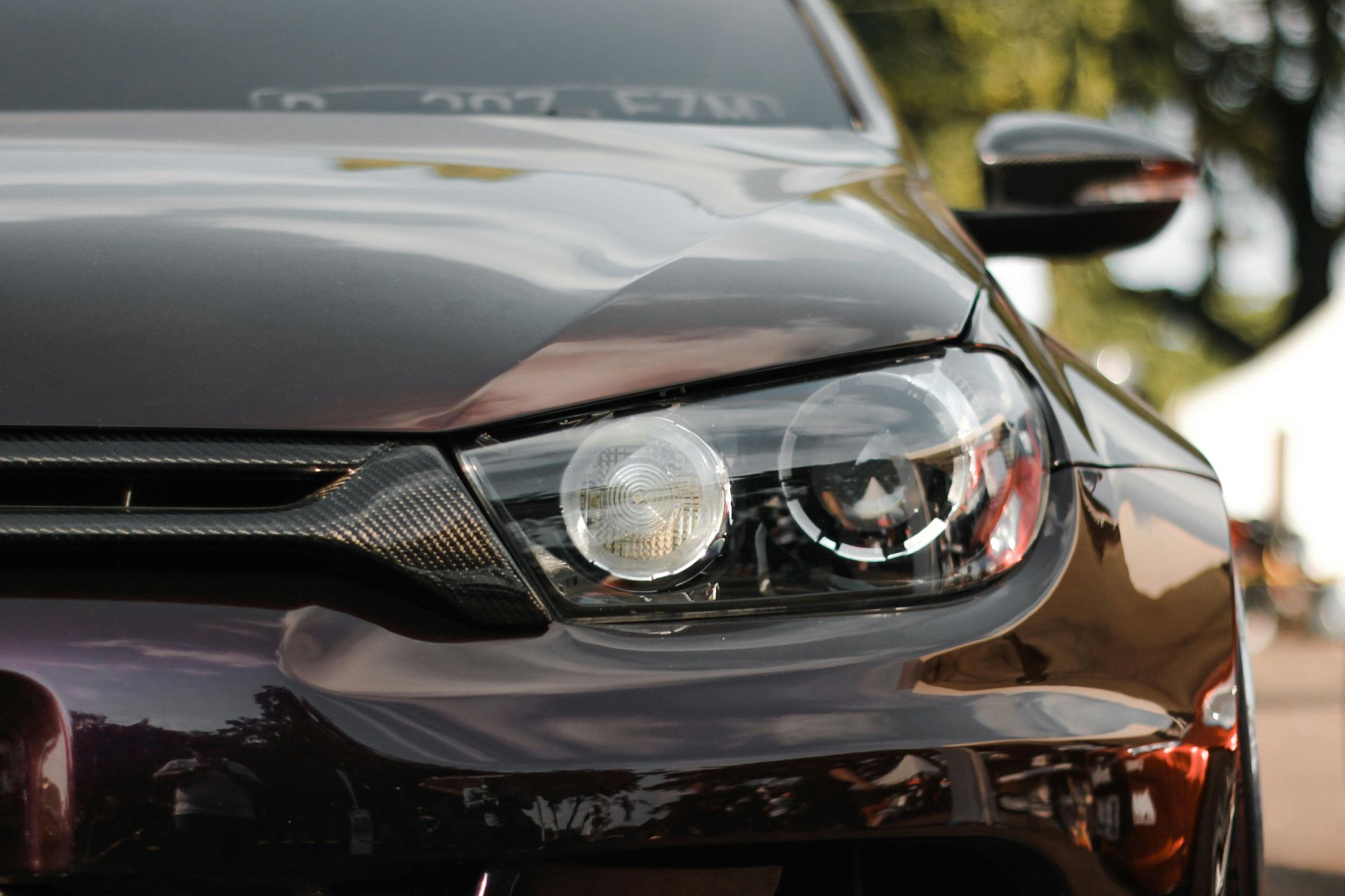 A close up of the headlights of a black car