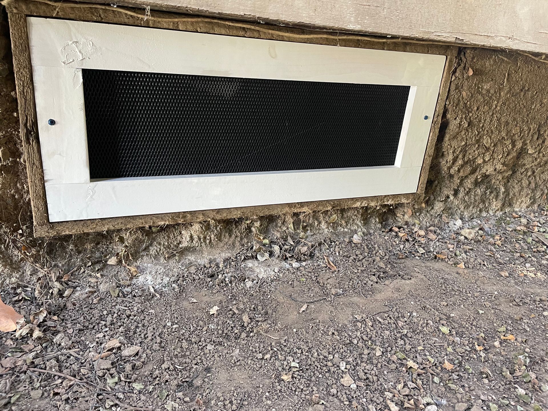 a window with a screen on it is sitting on the ground next to a wall