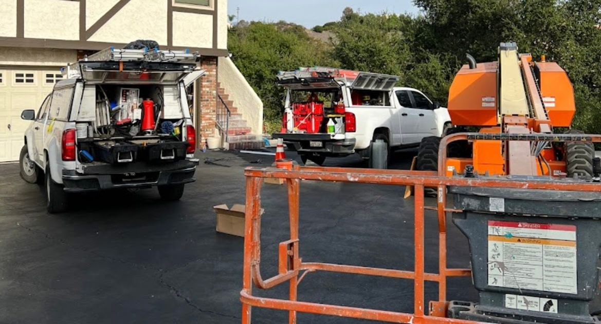 a couple of trucks parked in a driveway next to a house .