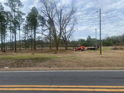 A tractor is parked on the side of the road next to a field.
