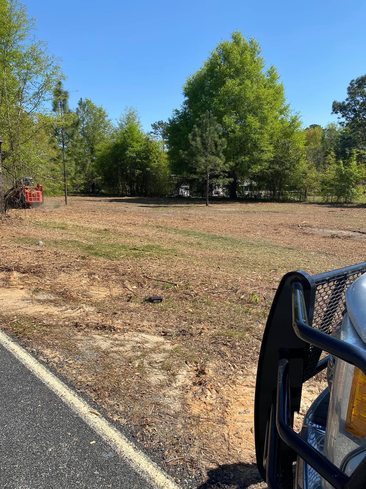 A truck is parked on the side of a road next to a field.