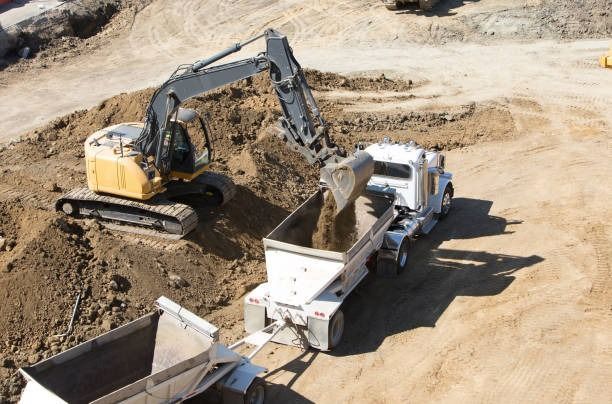 An excavator is loading dirt into a dump truck