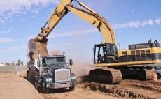 An excavator is loading dirt into a dump truck