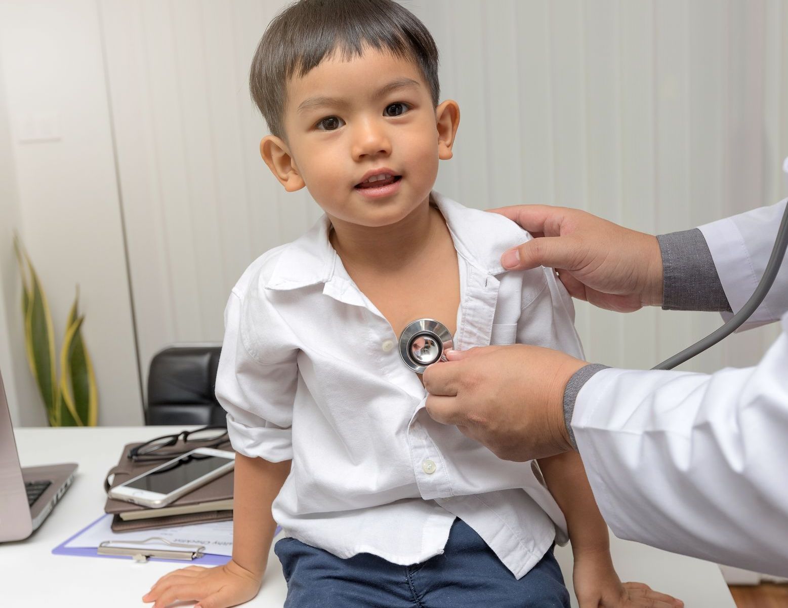 Pediatrician diagnosing boy