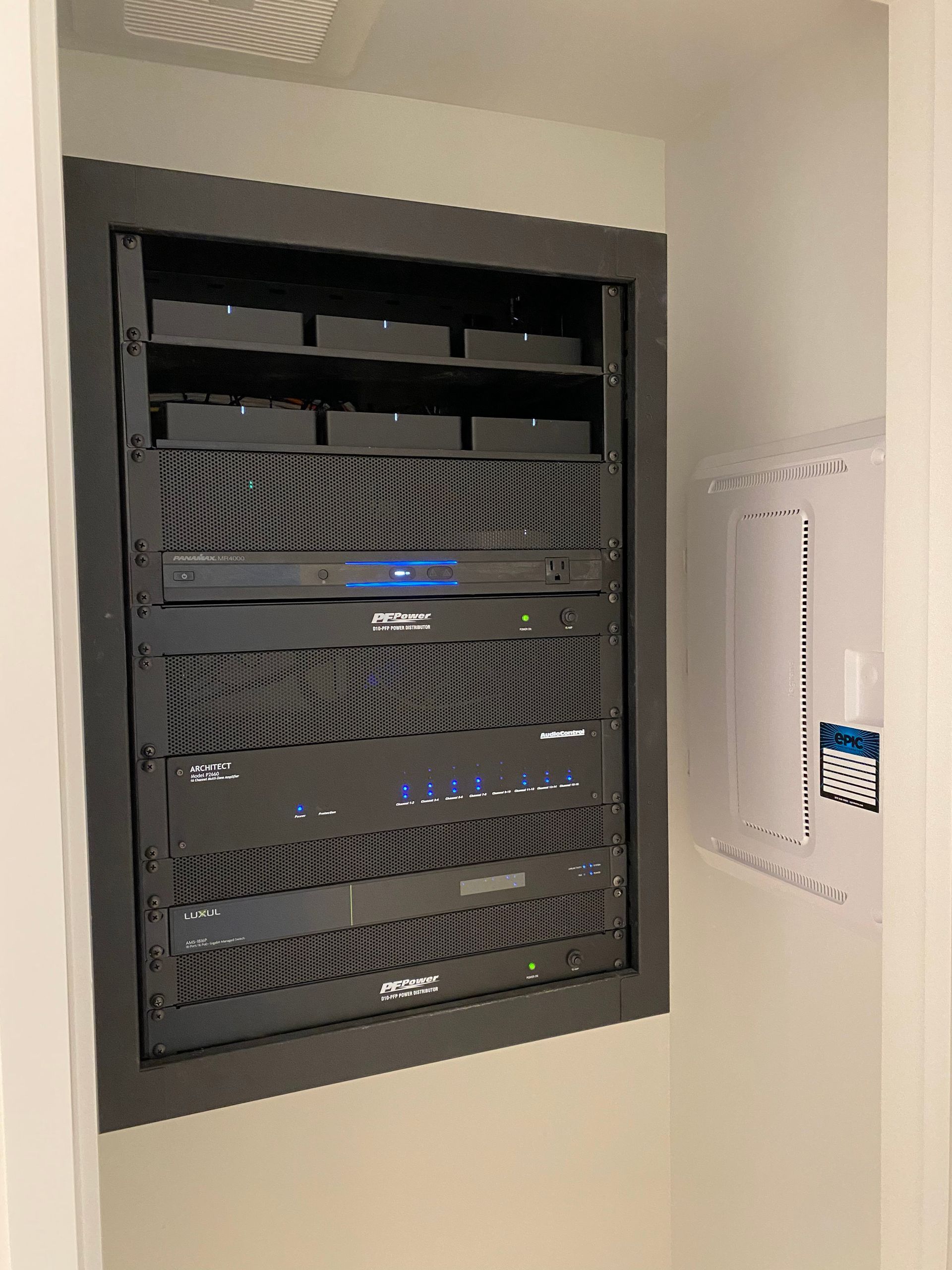 A server rack is built into a wall in a room.