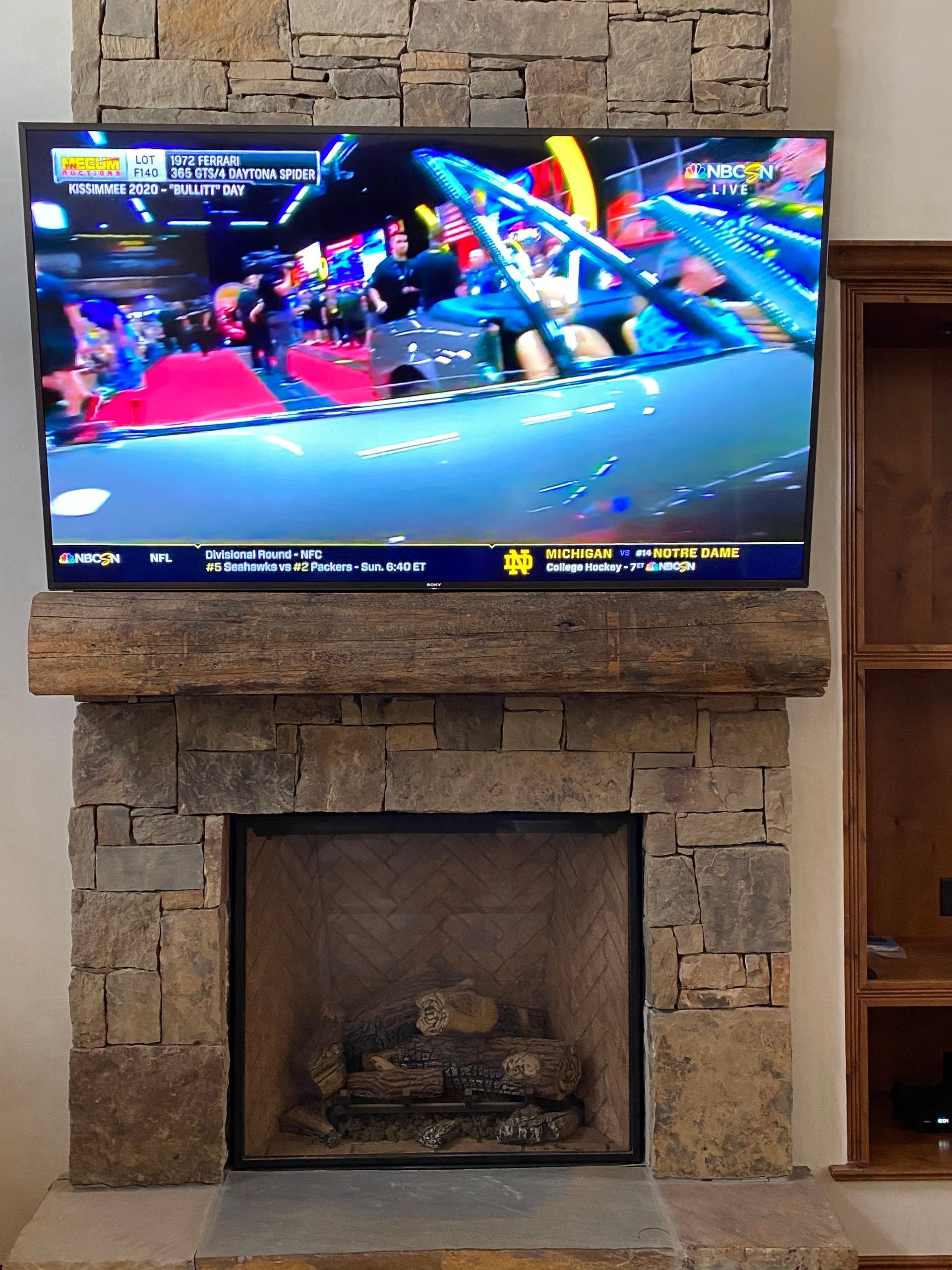 A flat screen tv is mounted above a fireplace