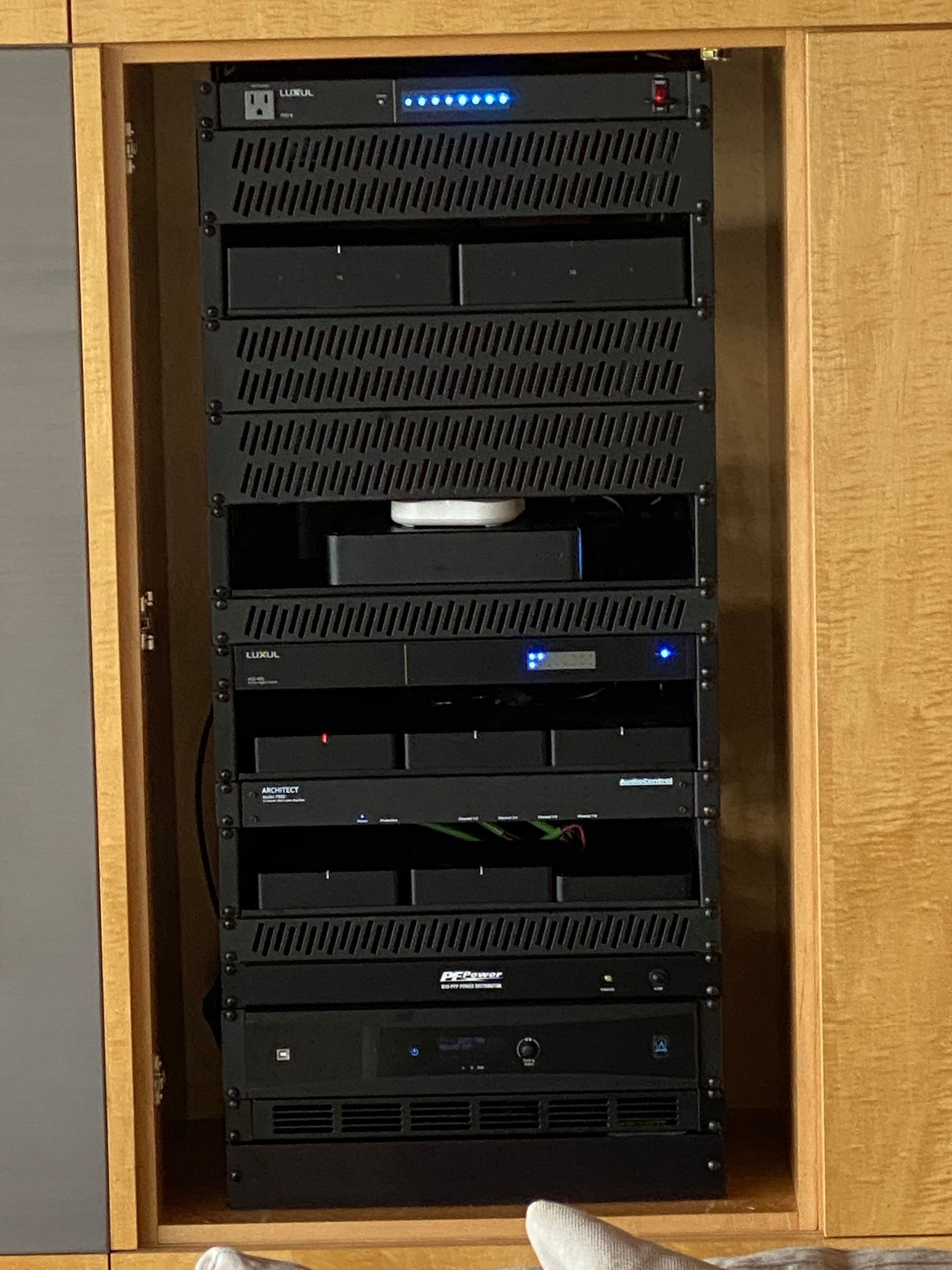 A stack of servers sitting inside of a wooden cabinet.