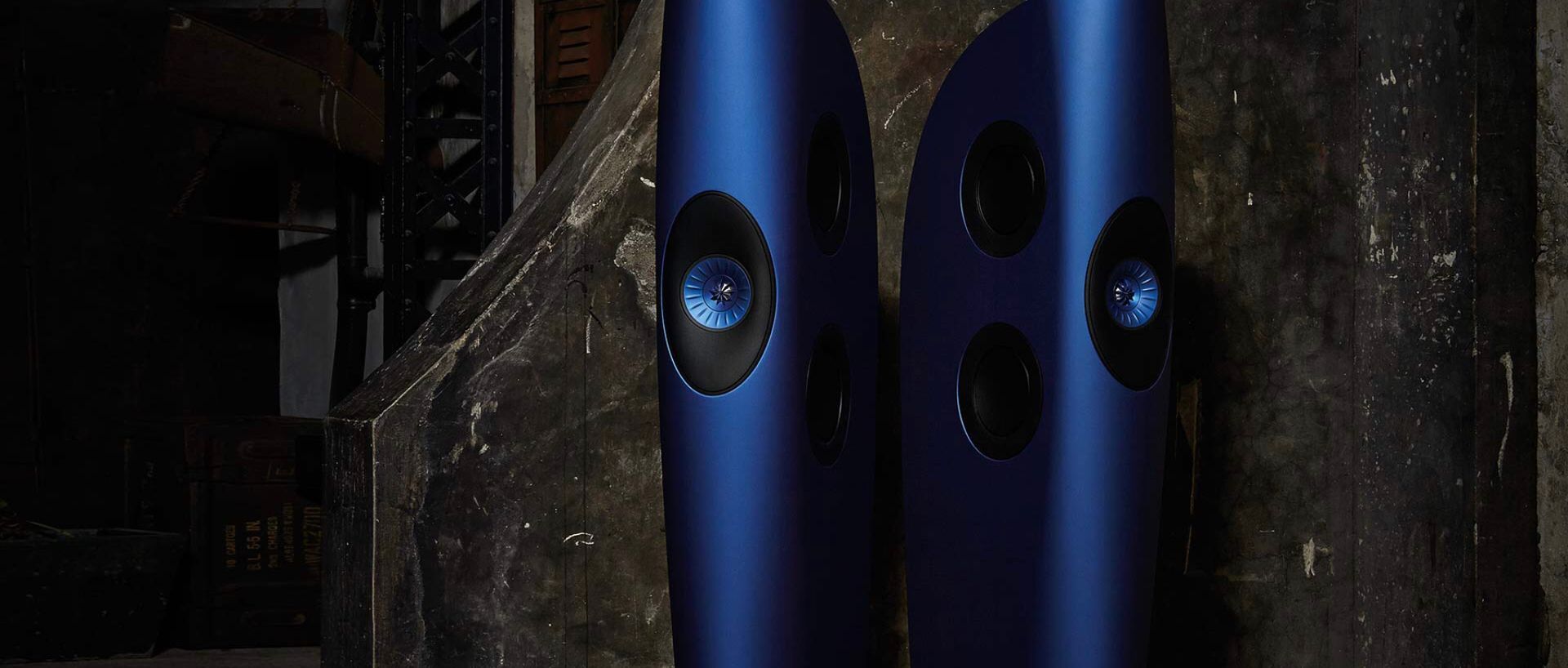 Two blue speakers are sitting next to each other on a staircase.