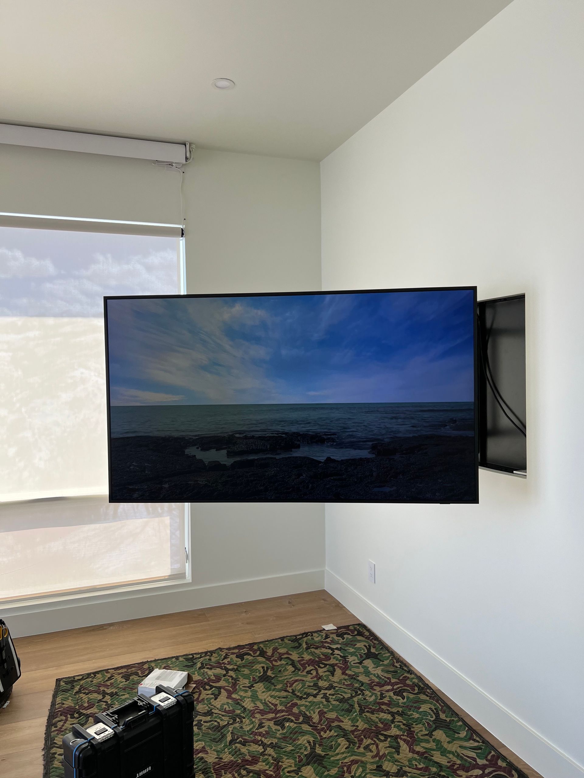A flat screen tv is mounted on a wall in a living room.