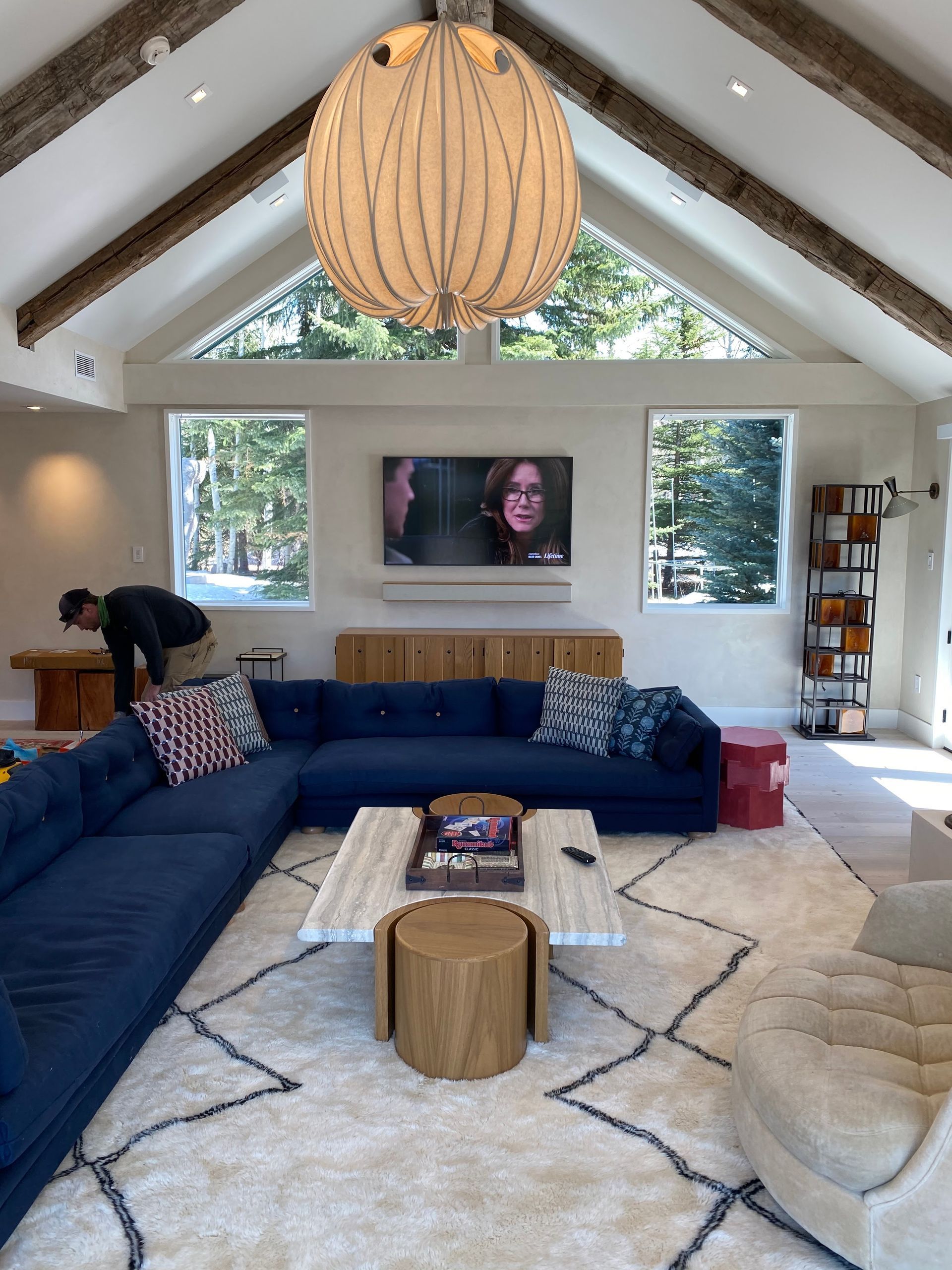 A living room with a blue couch and a white rug