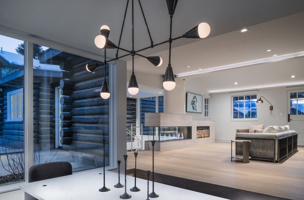 A dining room with a table and chairs and a chandelier hanging from the ceiling.