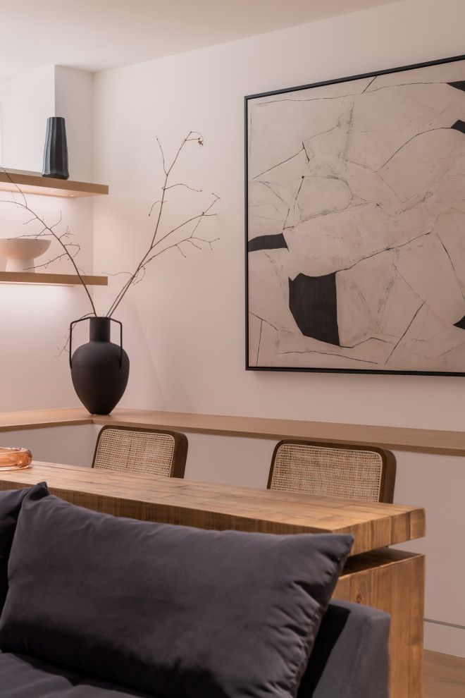 A living room with a couch , table , chairs and a painting on the wall.