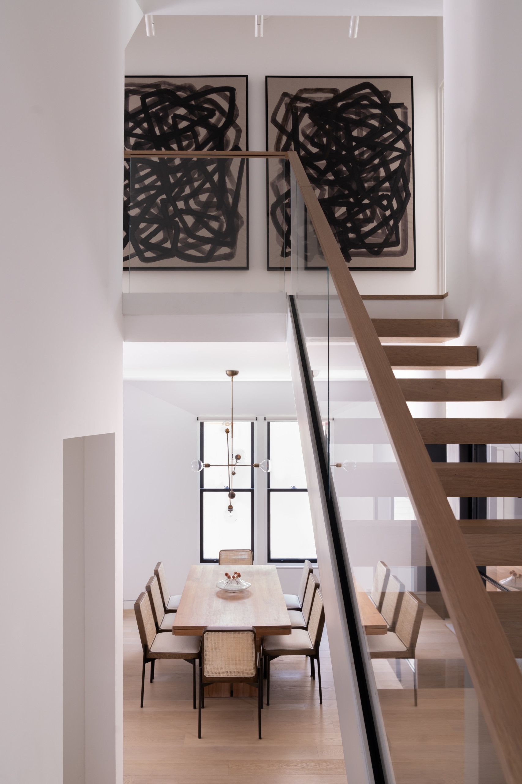 A staircase leading up to a dining room with a table and chairs