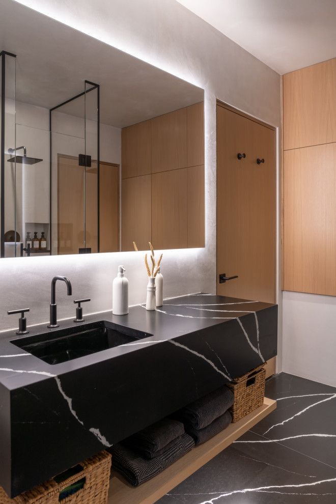 A bathroom with a black sink and a large mirror.