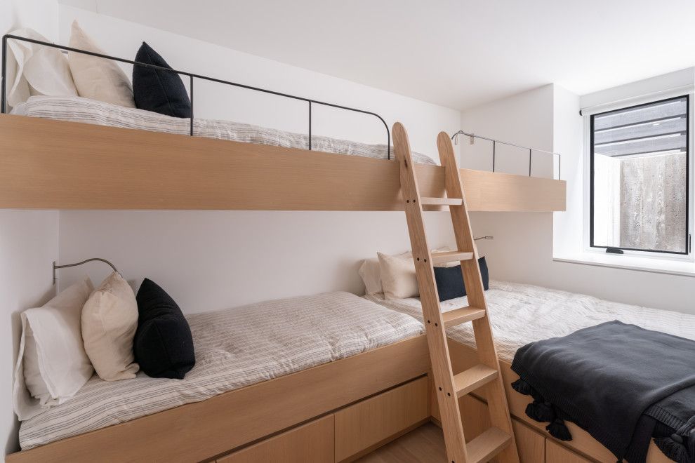A bedroom with three bunk beds and a ladder.