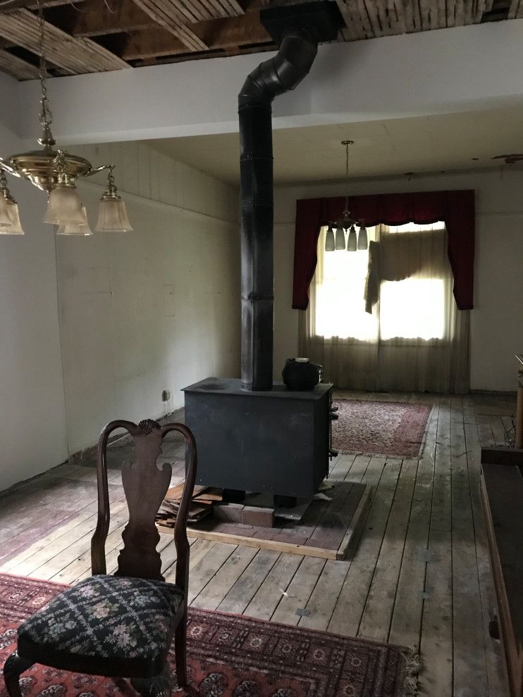 A living room with a wood stove and a chair