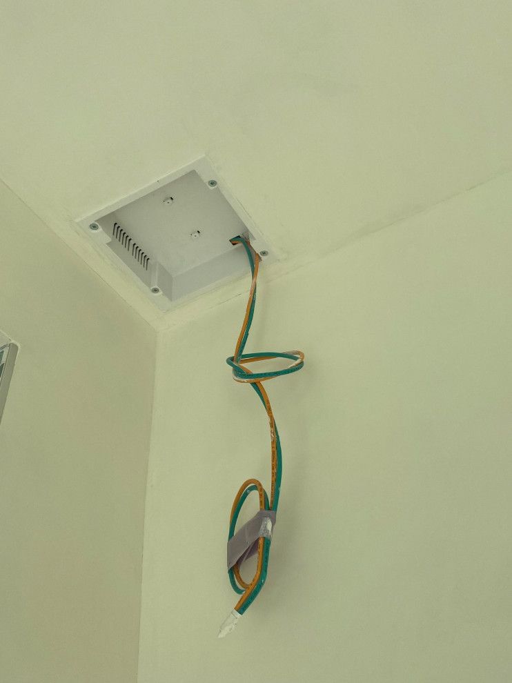 A green and yellow wire is hanging from the ceiling of a room.
