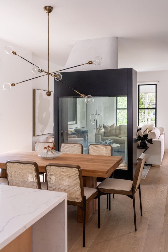 A dining room with a table and chairs and a fireplace.