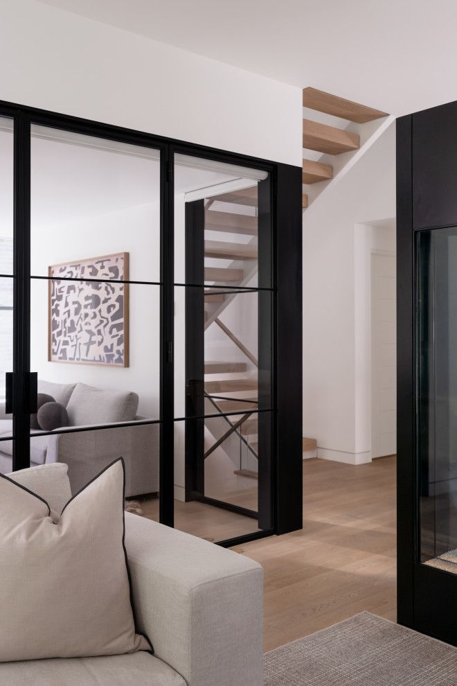 A living room with a couch , fireplace and stairs.