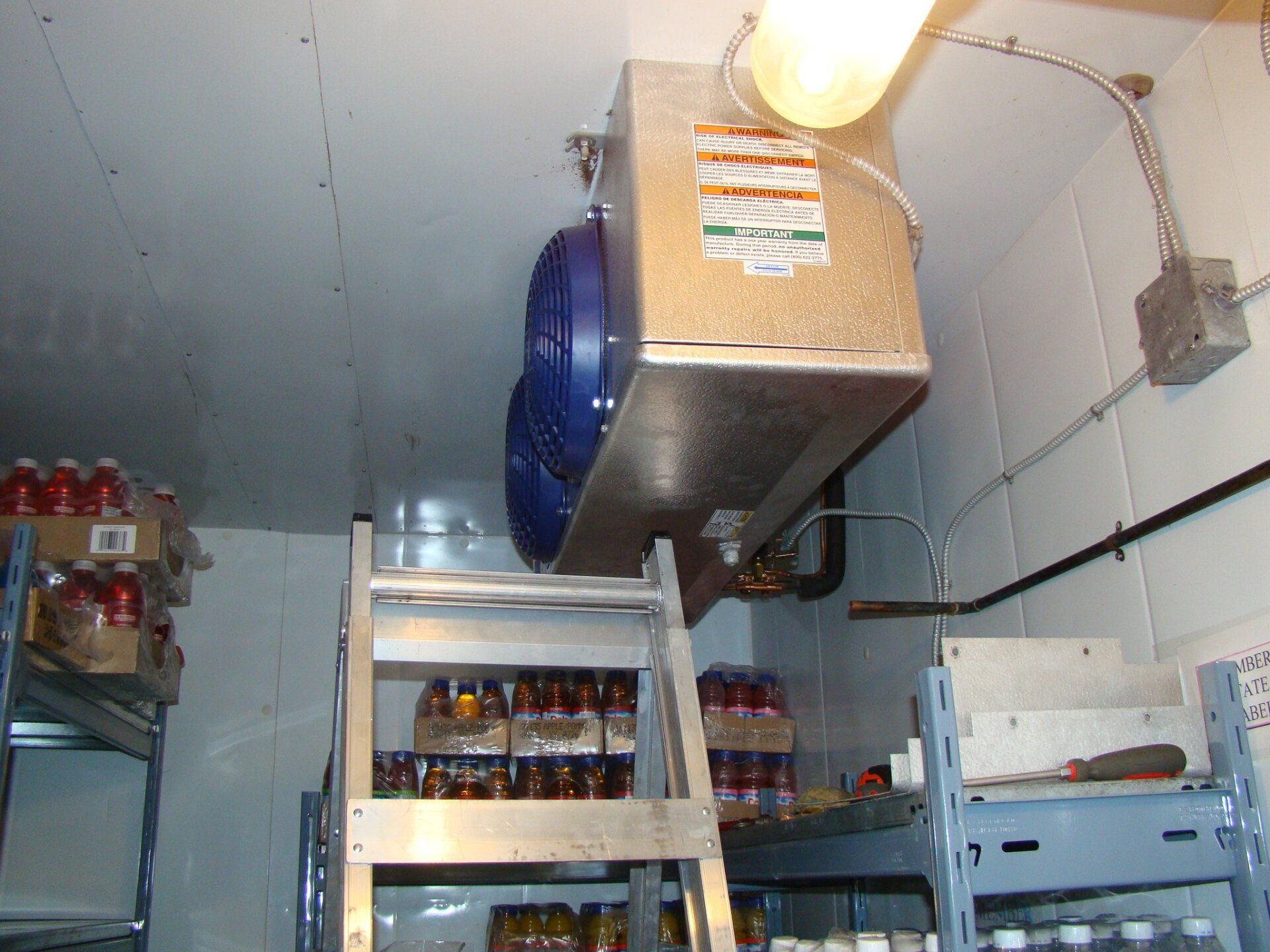A room with a ladder and a fan on the ceiling