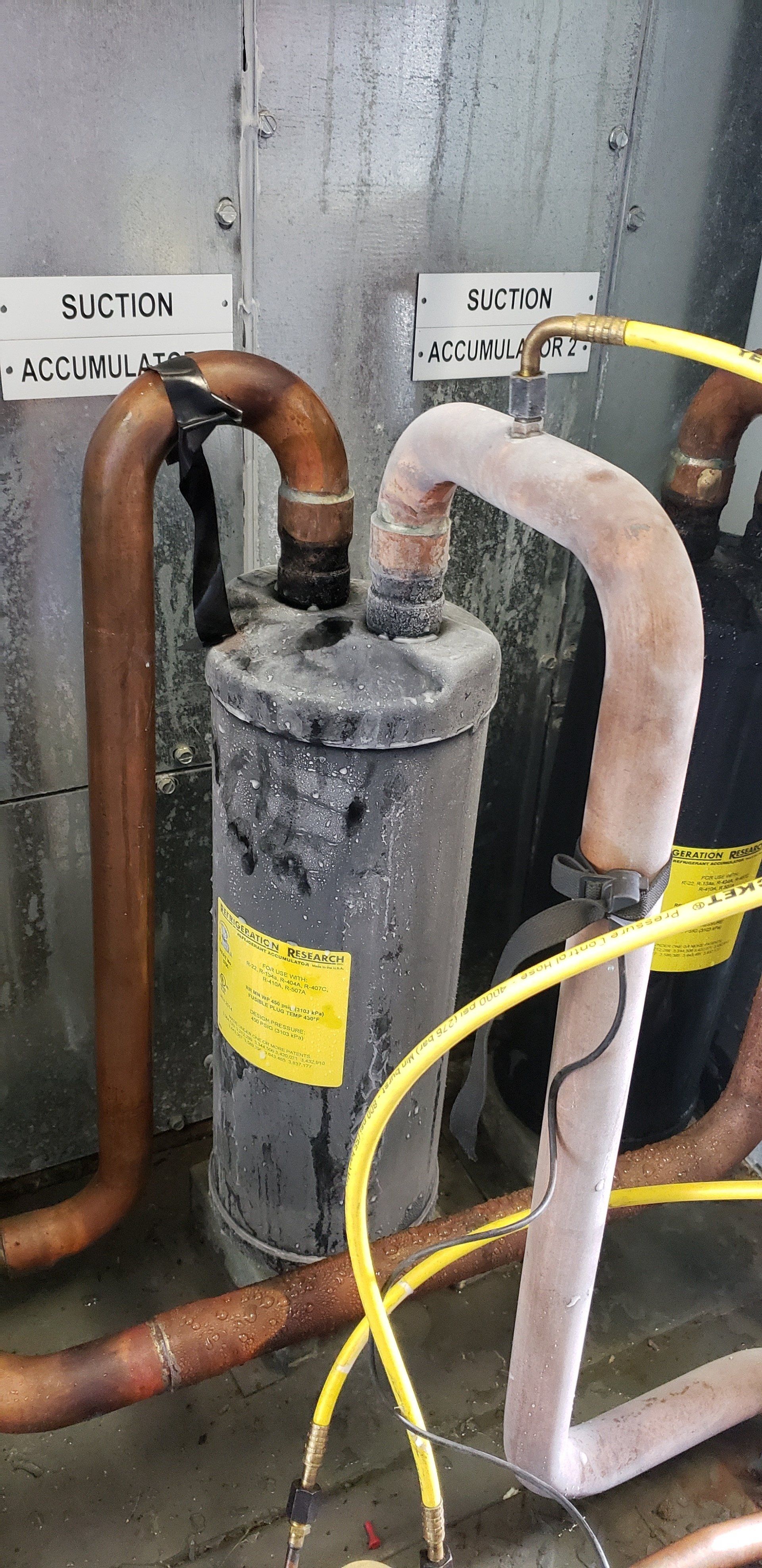 A close up of a pipe with a yellow hose attached to it.