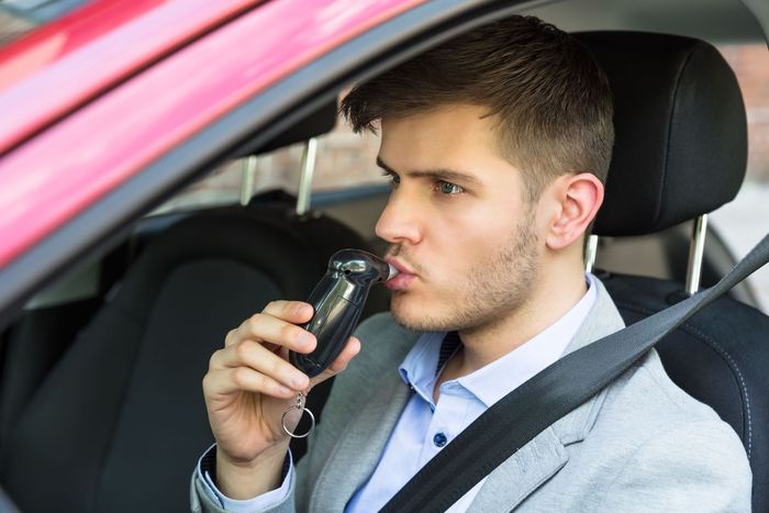 close young man sitting inside car