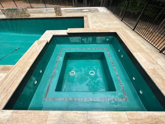 A large swimming pool with a jacuzzi in the middle of it.