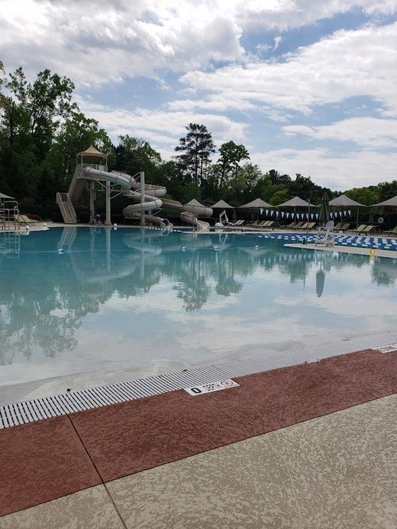 A large swimming pool with a water slide in the background