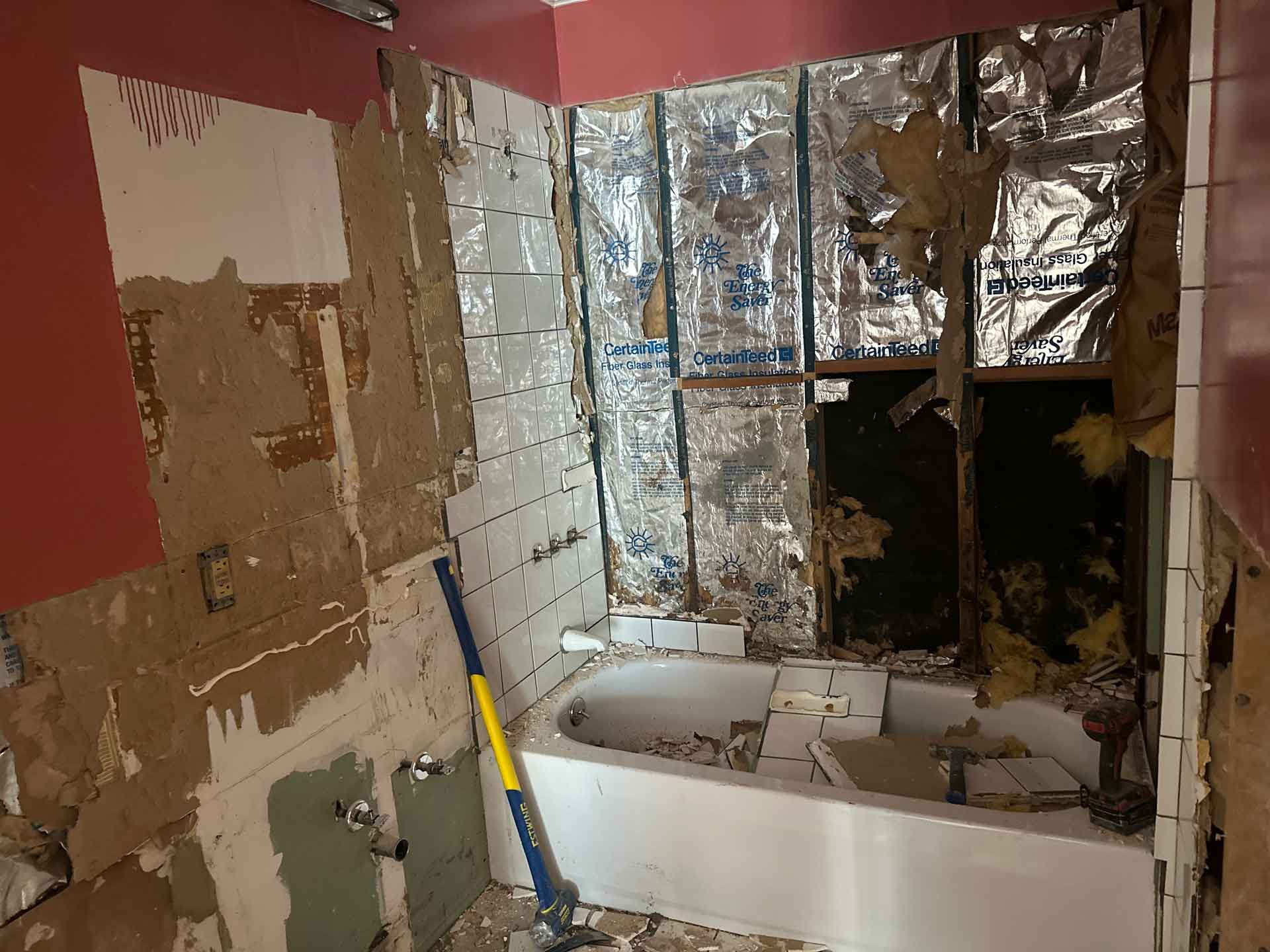 A bathroom with a bathtub and a mop in it