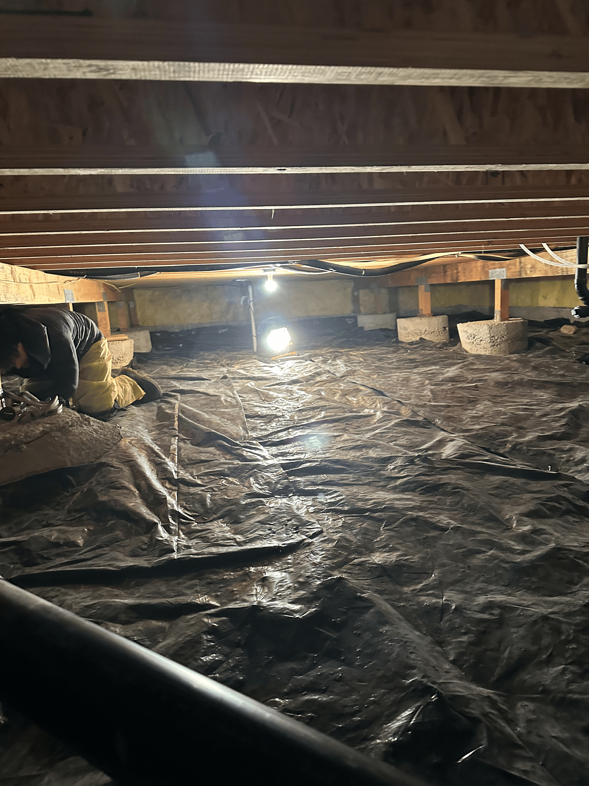 There is a light shining through the ceiling of a basement.