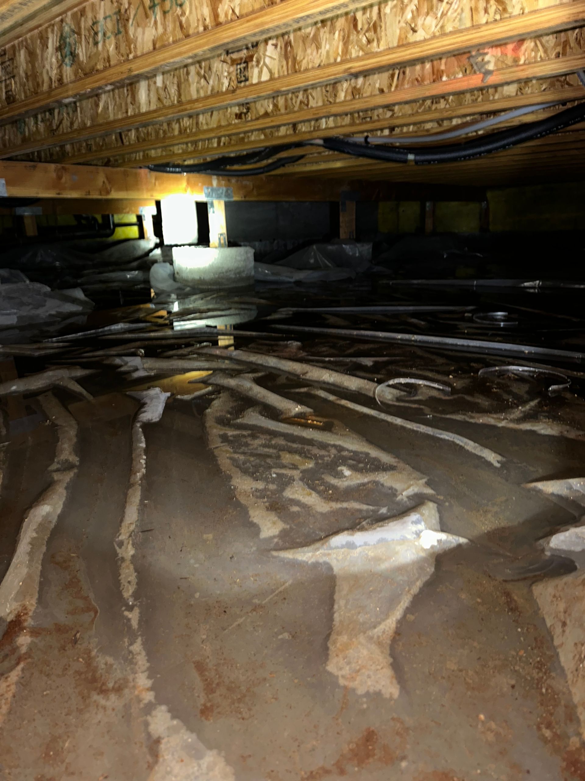 A flooded basement with a lot of water coming out of it.