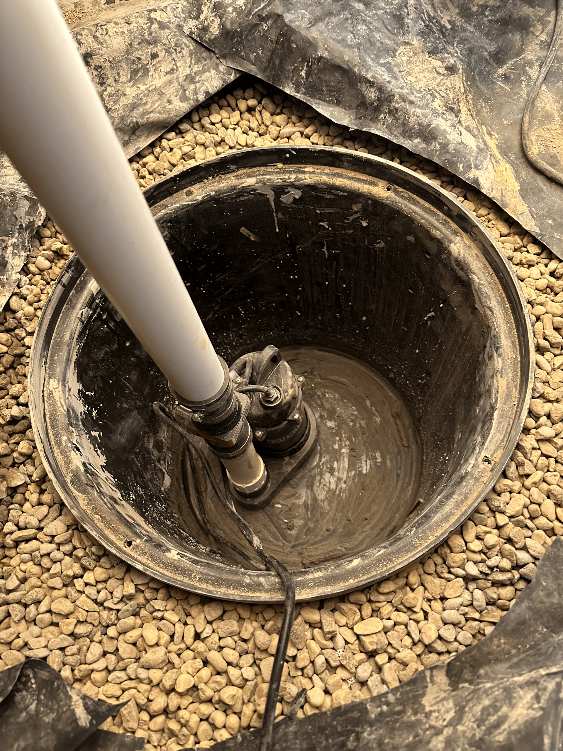 A person is pouring concrete into a hole in the ground.