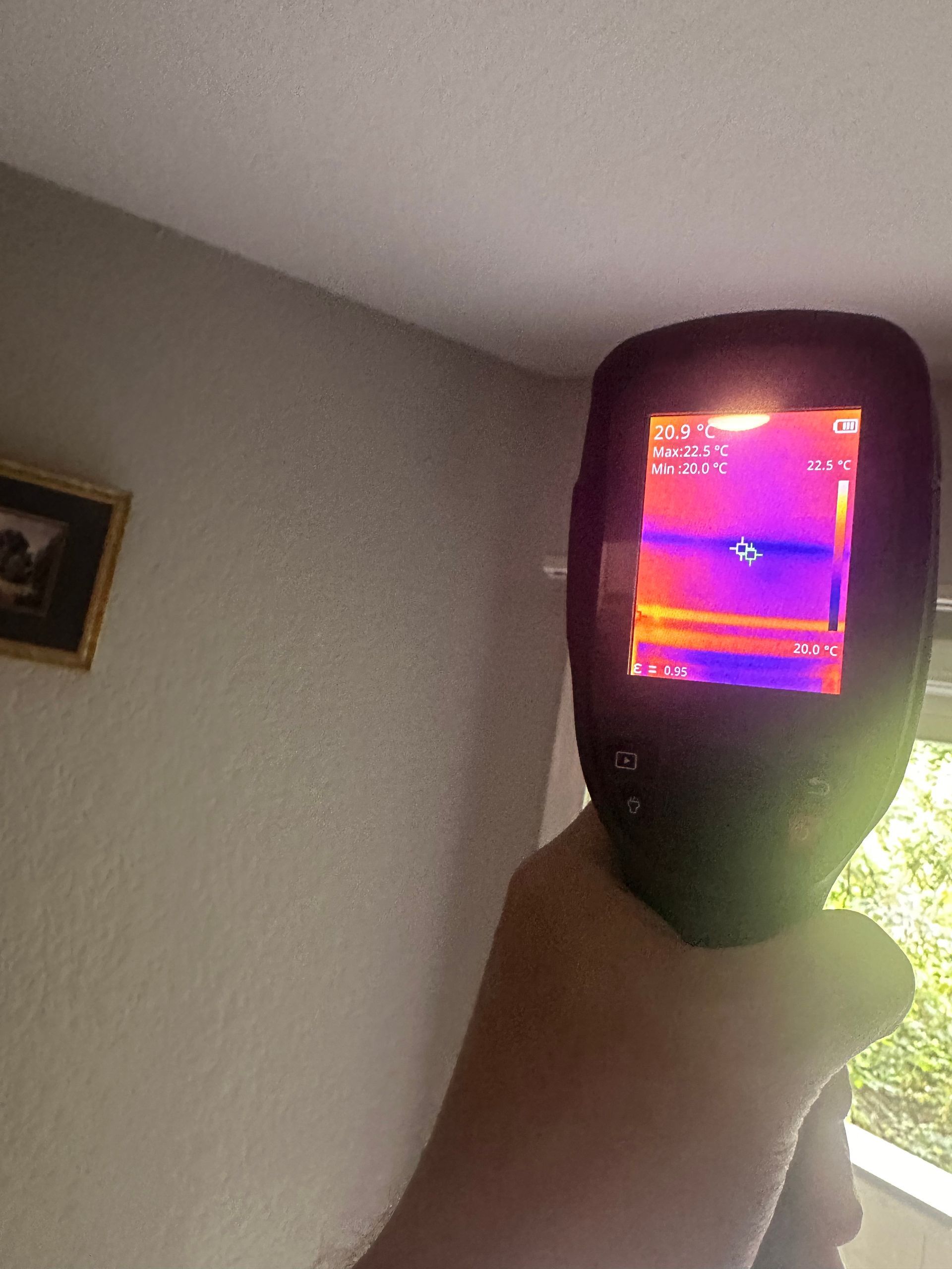 A person is holding a thermal camera in their hand.