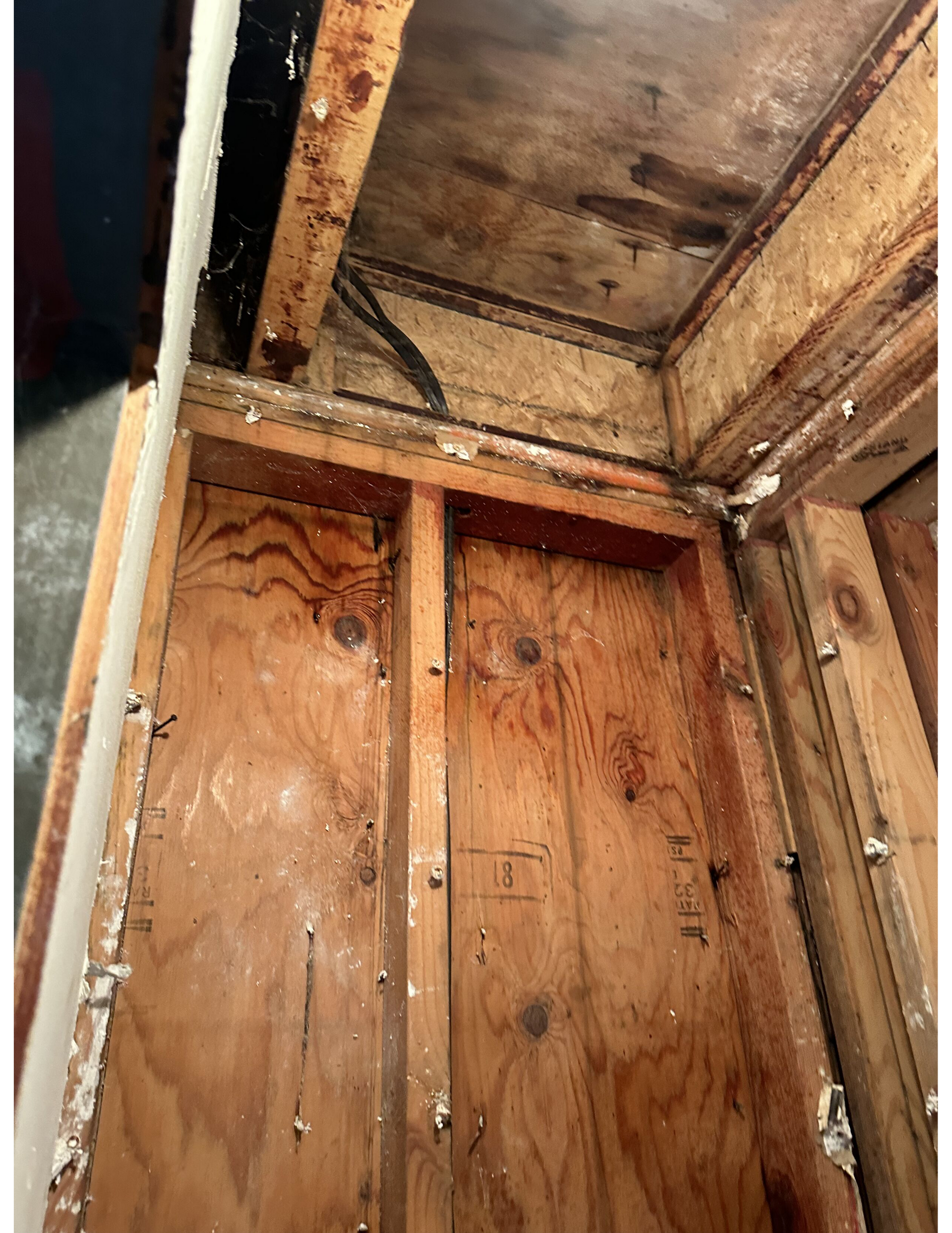 A close up of a wooden wall with a hole in it.