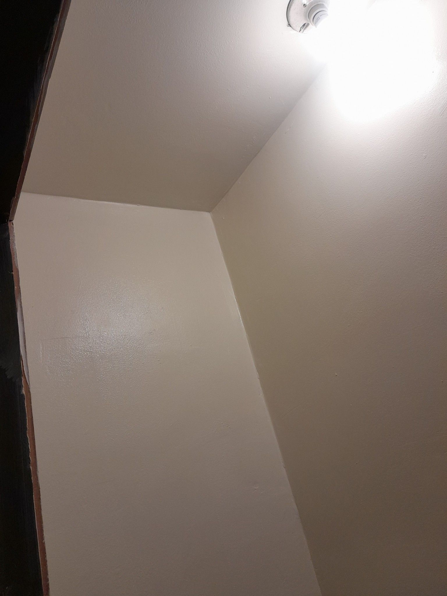 A room with white walls and a light on the ceiling.