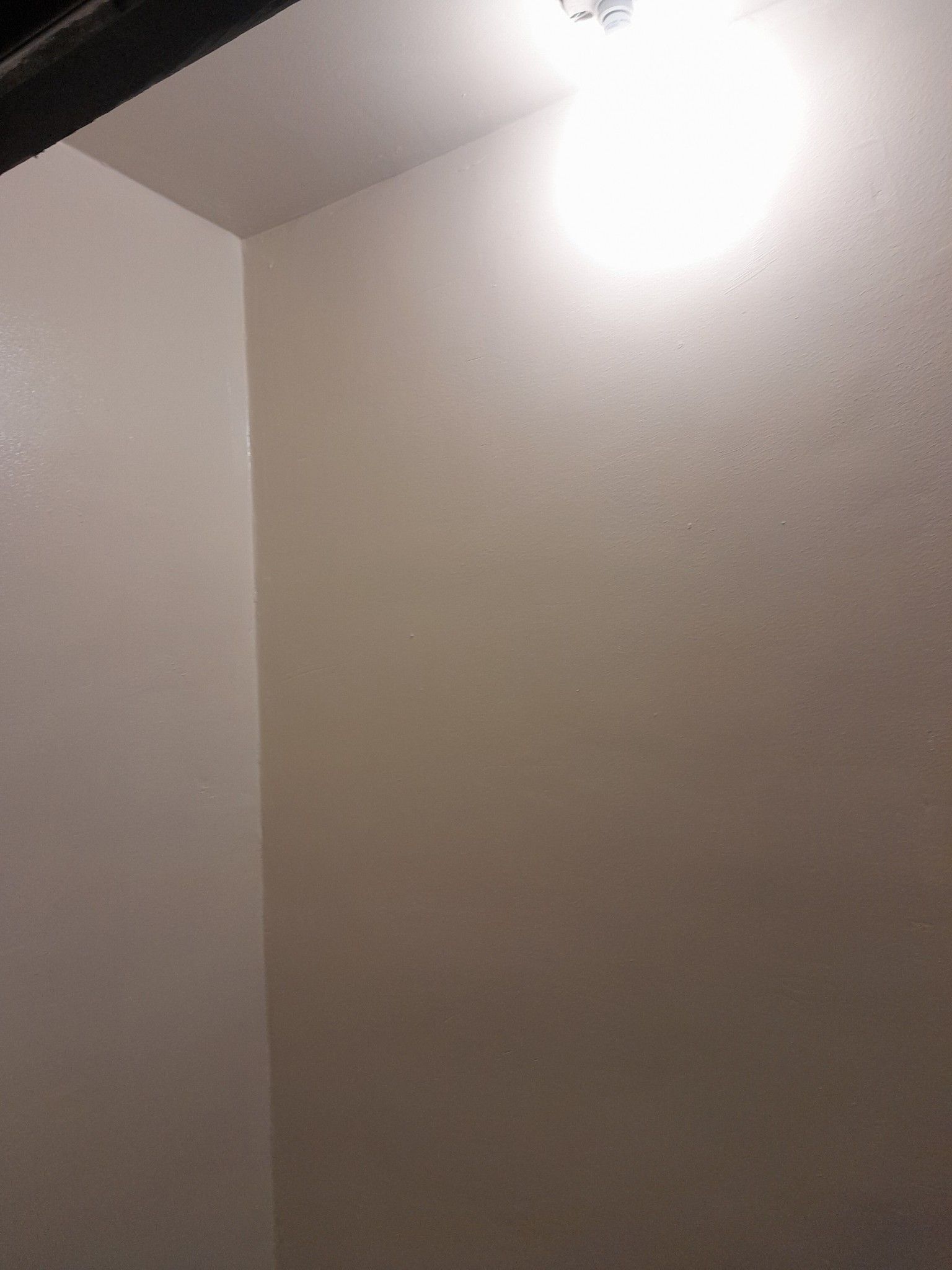There is a light on the ceiling in the corner of the room.