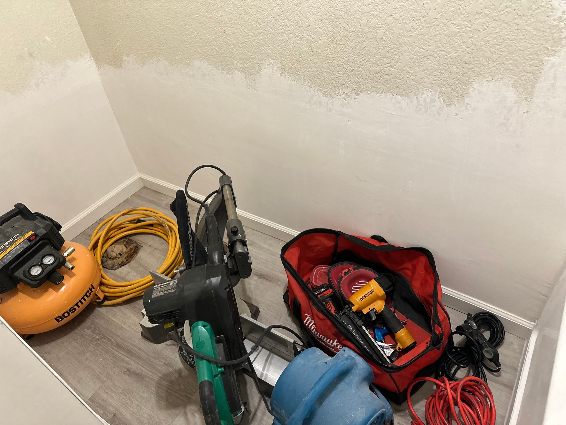 A bunch of tools are sitting on the floor in a room.