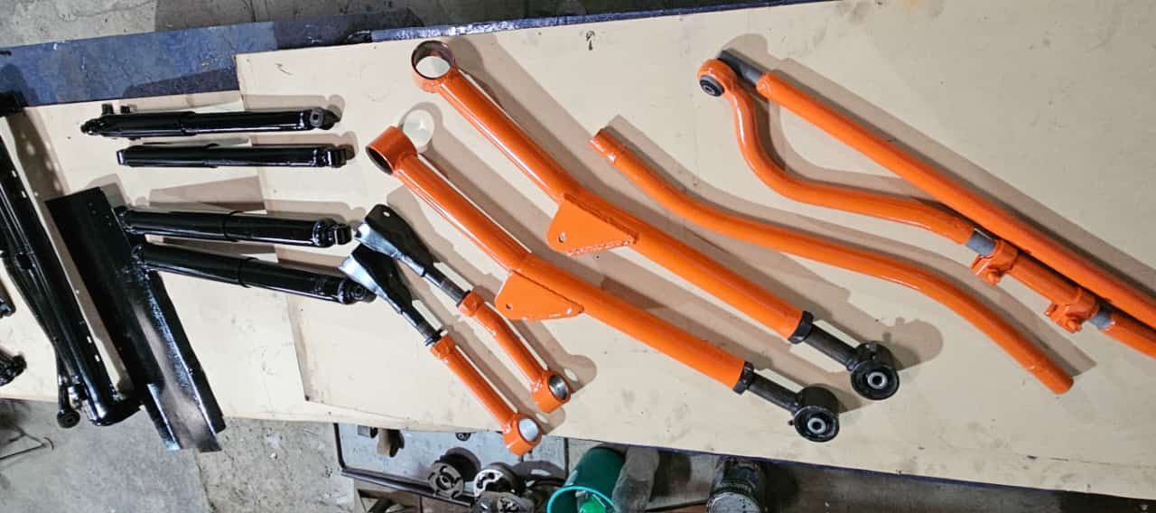 Un montón de piezas de metal de color naranja están sobre una mesa.