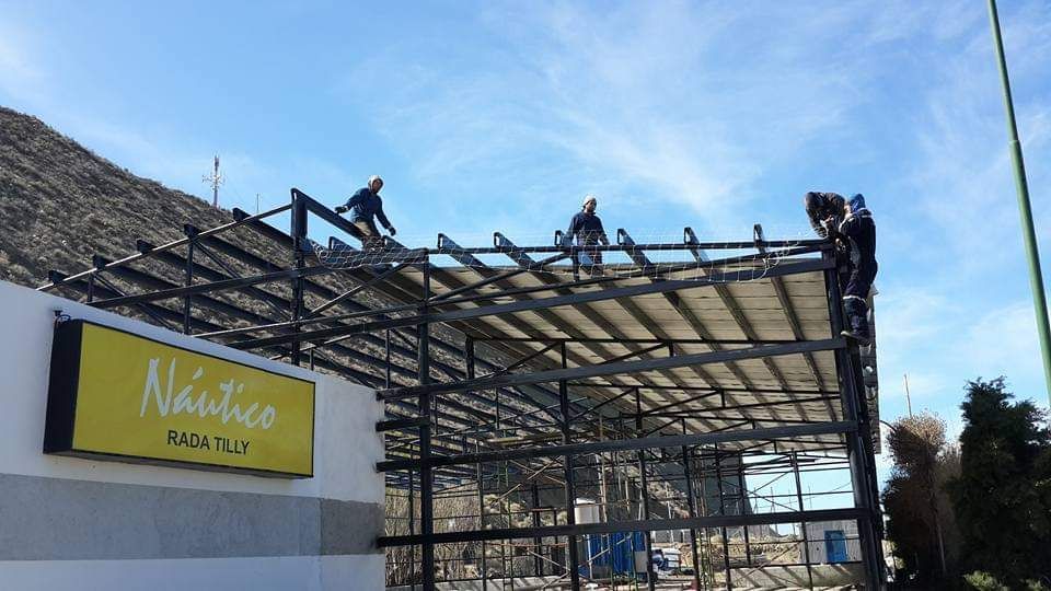 Un grupo de hombres está trabajando en el tejado de un edificio.