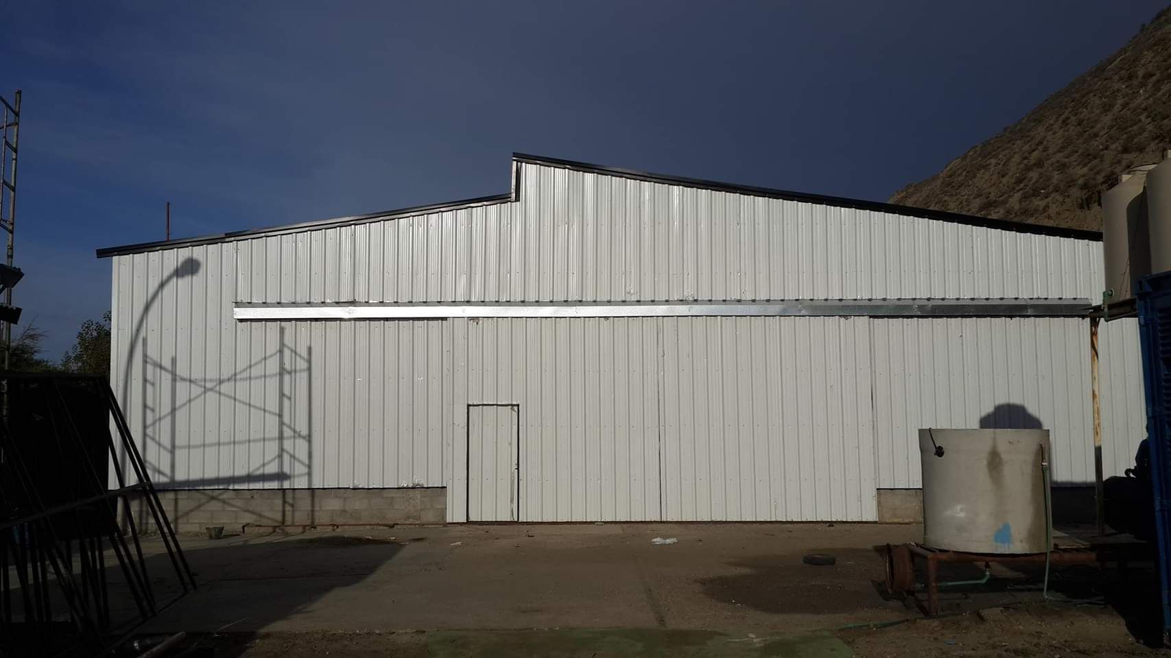 Un gran edificio de metal blanco con una puerta corrediza.