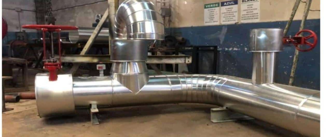 Un tubo de metal con una válvula roja está en una habitación.