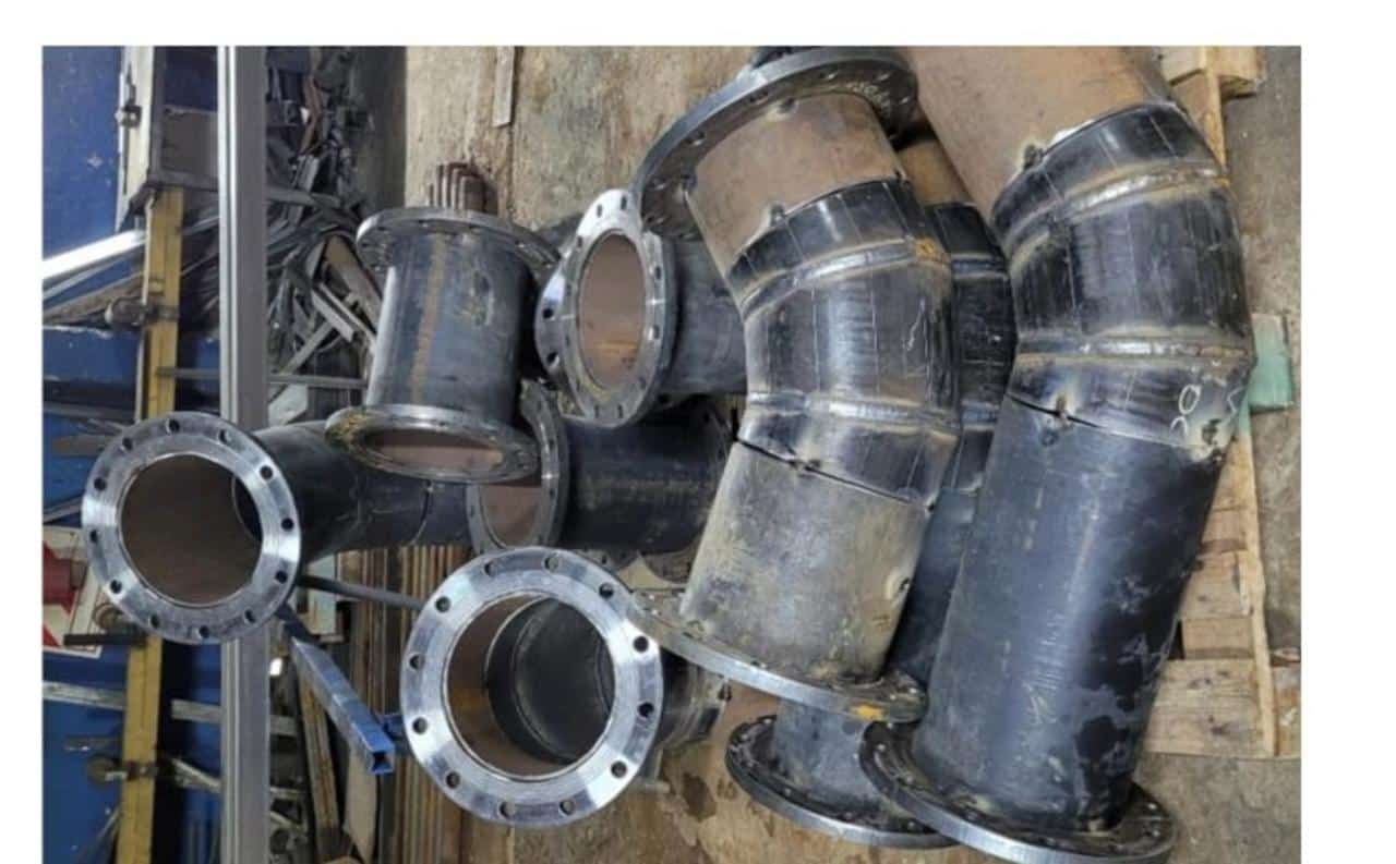 Un montón de tubos están apilados uno encima del otro sobre una mesa de madera.