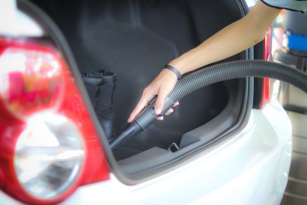 A Person Is Using A Vacuum Cleaner To Clean The Trunk Of A Car — Rocky Car Wash In Berserker, QLD