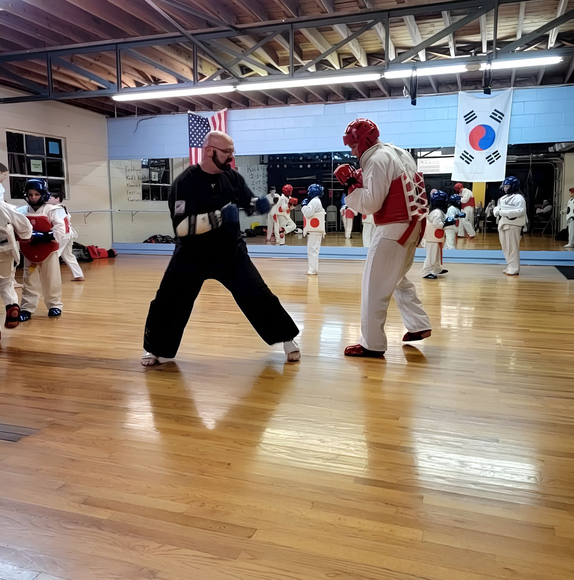 A group of people are practicing martial arts in a gym