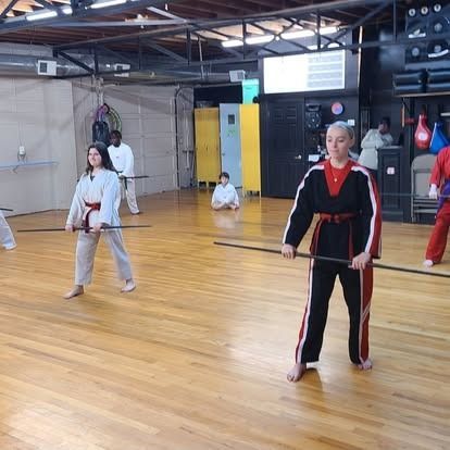 A group of people are practicing martial arts in a gym