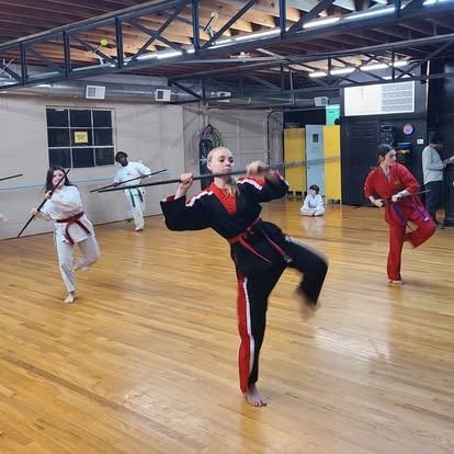 A group of people are practicing martial arts in a gym
