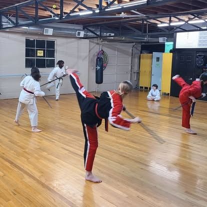A group of people are practicing martial arts in a gym.