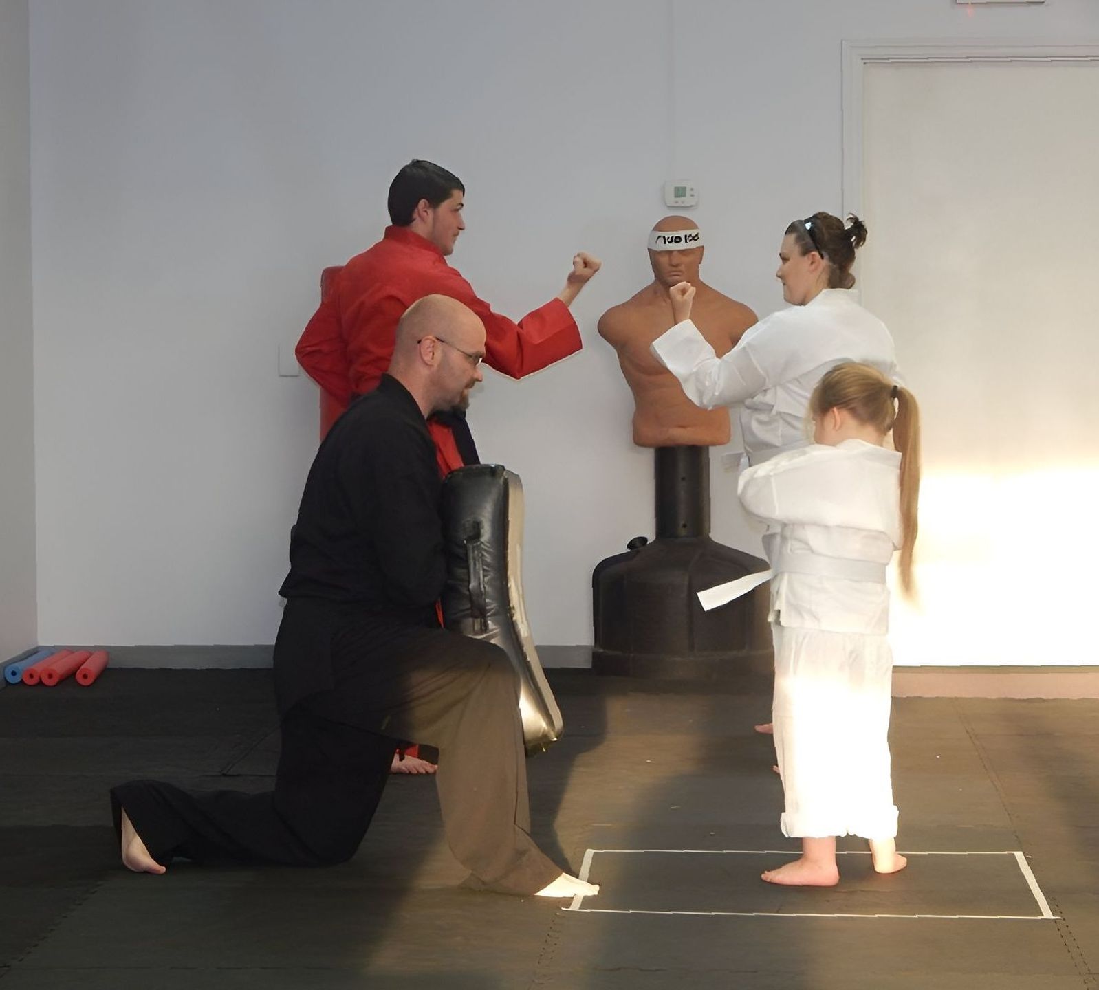 A group of people are practicing martial arts in a gym